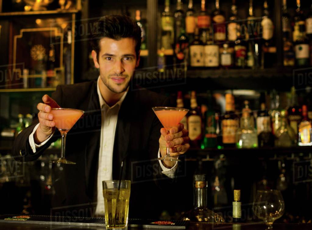 white male bartender offering up two orange cocktails, stock photo print covers the image